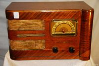 Front view showing walnut veneer cabinet, cloth speaker grille, tuning dial and control knobs