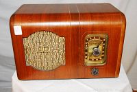 Front view of restored DeForest vintage radio with wooden cabinet, speaker grille, and tuning dial.