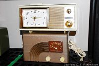 View showing both radios stacked, Northern Electric radio with brown Bakelite case and Bulova white plastic clock radio on top