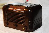 Front left angled view of brown Bakelite RCA Victor radio showing casing and control knobs.