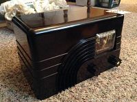 Front and top angle view of the brown Bakelite radio showing the smooth, shiny finish and streamlined design.