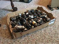 Box of assorted vintage radio tubes showing many tubes piled with visible labels and prongs.