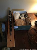 Overview photo showing the wooden display stand with tubes set in holes, adjacent to a box filled with vacuum tubes wrapped in paper and loose ones.