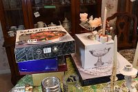 Full lot view showing stacked boxes including Bowring pedestal bowl and Crystal d'Arques glasses, candle holders with floral candles, ceramic mugs, and pedestal bowl box.