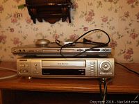 Photo showing stacked Samsung VHS player (bottom) and another device featuring multiple ports (top).