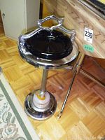Side view of the vintage standing ashtray showing the full height, stick/poker attached to the side, and weighted base.