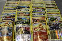 Photo showing multiple rows of assorted Pokemon trading cards including foils and various Pokemon characters