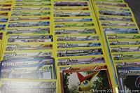 Photo showing multiple Pokemon trading cards fanned out in rows with some visible foil cards.