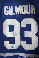 Back of blue Toronto Maple Leafs jersey with GILMOUR name and number 93, autographed on the 9, showing smoke and dirt marks.