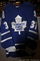 Front view of blue Toronto Maple Leafs hockey jersey with white maple leaf logo and number 31 on sleeves, showing smoke and dirt damage.