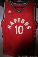 Front view of red Toronto Raptors basketball jersey with number 10, Adidas logo, showing dirt and smoke damage.