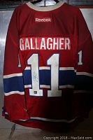 Full back view of the red Reebok Montreal Canadiens jersey with number 11 and 'GALLAGHER' name, showing autograph on one of the numbers and worn, dirty fabric condition.