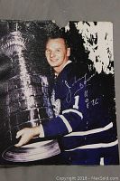Front view of the 8x10 photo showing Johnny Bower holding the Stanley Cup. Top right corner shows fire damage and tear.