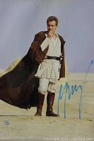 Full 8x10 photo of Ewan McGregor in Jedi costume with autograph and slight discoloration along top edge.