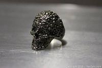 Front angled view of pewter skull ring showing detailed textured surface shaped like a skull.