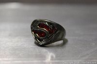 Front and side view showing pewter Superman ring with red enamel 'S' emblem.