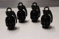 Four black hand grenade shaped valve caps shown grouped together on a white surface.
