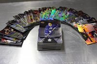 Photo showing large fanned-out and stacked assortment of Tim Hortons hockey cards including holographic versions.