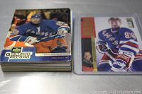 Stack of Wayne Gretzky hockey cards packing more than 20 individual cards, showing player in blue hockey jersey.
