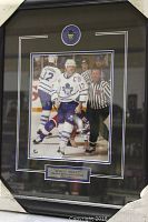 Framed and matted action photo of Wendel Clark in Toronto Maple Leafs uniform, showing full frame and mat with plaque under photo.