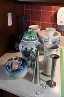 Front view of assorted vases showing floral and metallic designs.