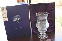 Edinburgh Crystal candle holder displayed next to its blue presentation box all sitting on a wooden surface, showing the full item and packaging.