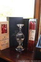 Mikasa Platinum crystal candleholder boxed with two boxes of red candles, placed on a wooden windowsill.