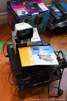 Front angle showing Kodak Carousel projector with Lumex viewer and manual on top, cables visible.