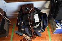 Bag with multiple vintage camera bodies and accessories piled inside