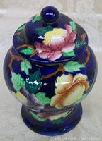 Front view of antique Maling ginger jar with lid on, showing dark blue base color and colorful floral patterns.