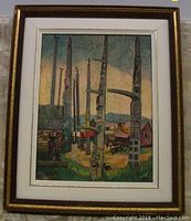 Framed print showing tall Haida totem poles in a small town setting with surrounding buildings and people in the background.