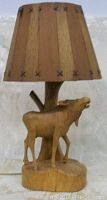Front view of carved wood lamp with stag and wooden slat shade showing the front side details.