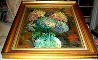 Framed colorful impressionist oil painting of hydrangeas in a green vase with visible brushstrokes. Signature Jean Hubert visible on lower right.