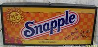 Front view of the Snapple light up advertising sign, showing logo and sun graphic, bright orange and yellow background with slogan text.