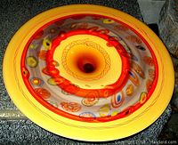 Top-down view of the blown spun glass Murano Venetian art glass bowl showing the vibrant orange center and surrounding multicolored Millifiori patterns with yellow outer rim.