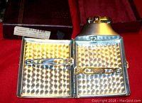 Open case interior showing engine-turned pattern and dual cigarette clips