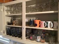 Six shelves of mixed glassware and mugs including silver rimmed wine glasses, martini glasses, water goblets, cordials, champagne flutes, highballs, old fashioned glasses, iced tea glasses, sherbet glasses, assorted mugs and cups.