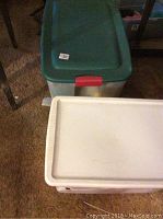 Photo of two storage bins with lids, showing closed bins containing Christmas decorations and wrapping paper