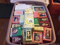 Top view of bin containing over 30 boxed Enesco Precious Moments figurines tightly packed together showing original boxes with various designs and colors.