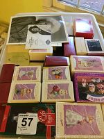 A bin with multiple neatly stacked Hallmark Keepsake ornament boxes, mostly pastel purple and white boxes with various animal and figure designs visible.