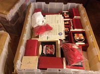 Plastic bin filled with over 30 Hallmark Keepsake Ornaments in original boxes showing different sizes and red-themed packaging.