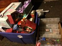 Purple plastic tote bin filled with Hallmark boxes, loose ornaments and a purple toy vehicle