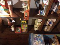 Shelf with two Crayola crayon tins among other items, showing colorful vintage Crayola logos and images.