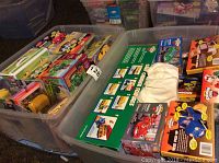 Overview of two plastic bins filled with unopened Chevron Cars promotional toy boxes