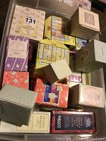 Photo shows approximately 30 boxed Precious Moments figurines and collectibles, varied sizes and boxed, packed in a container.