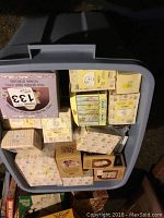 Top view of large storage bin filled with approximately 30 boxed Precious Moments figurines.