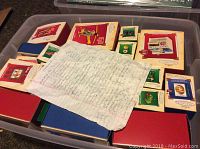 Plastic storage bin filled with Hallmark Keepsake ornament boxes and a handwritten inventory list placed on top.