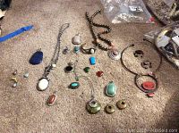 Overview of lot on carpet showing necklaces, pendants, earrings, bracelet and ring