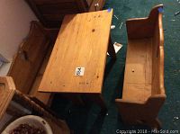 Set of wooden doll furniture including a doll table and two benches visible from above, placed on green carpet