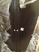 Front view of wrapped armoire doors with round knobs and lot sticker